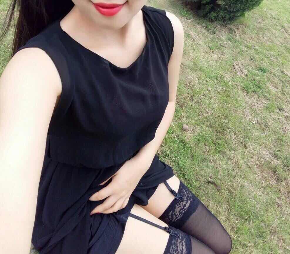 Detail of long nylon-clad legs extended along a sunlit park path with shadow play